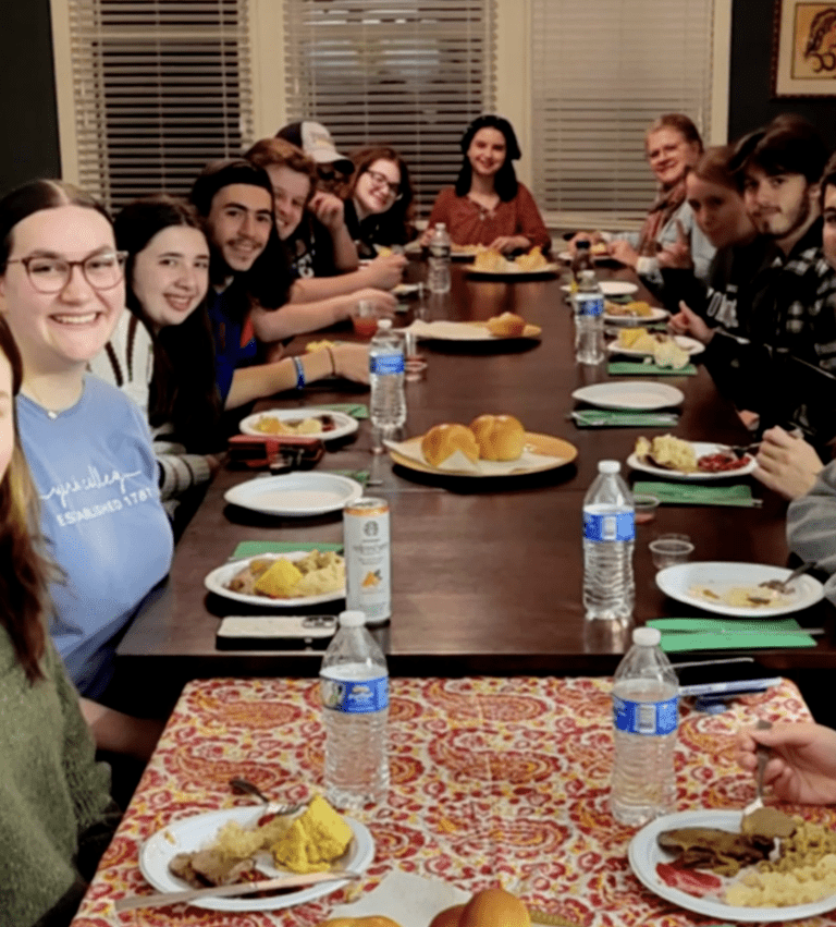 Students sharing a meal around a table in the Gordon Center