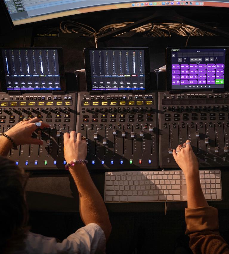 Two students working on equipment in the music production studio.