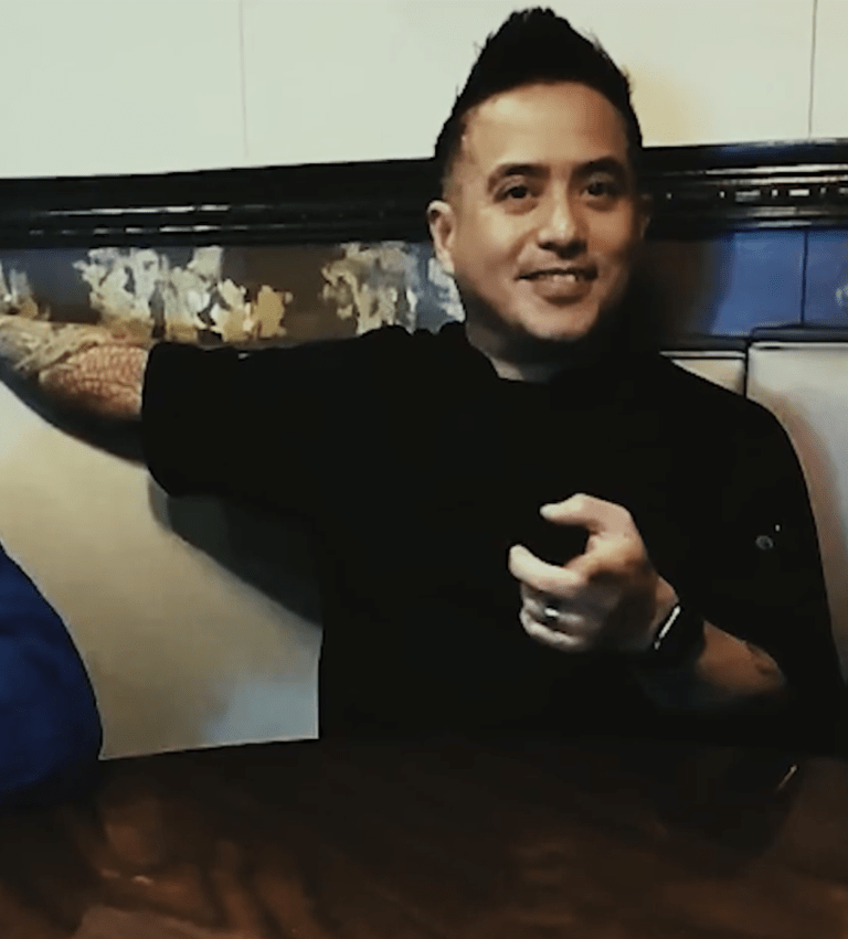 Three people sit together in a restaurant booth