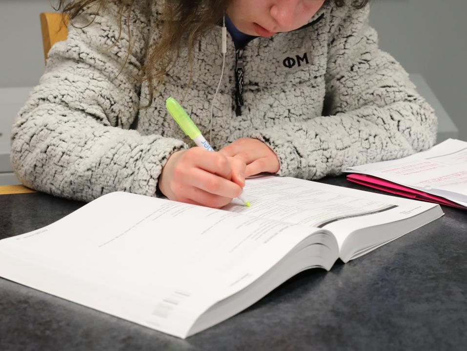 A student is in Schmidt Library working on assignments for class