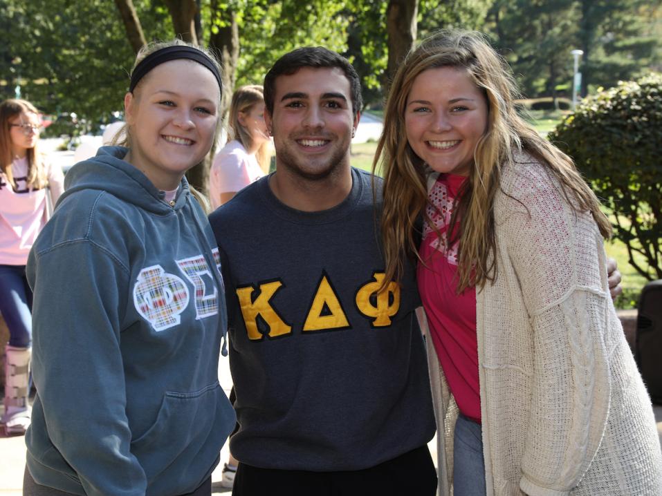 Three Greek Life students smiling at the camera.