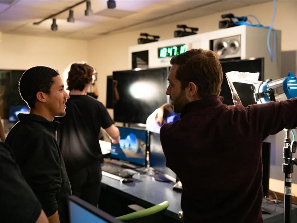 Students in the news studio learning how to operate lighting equipment.