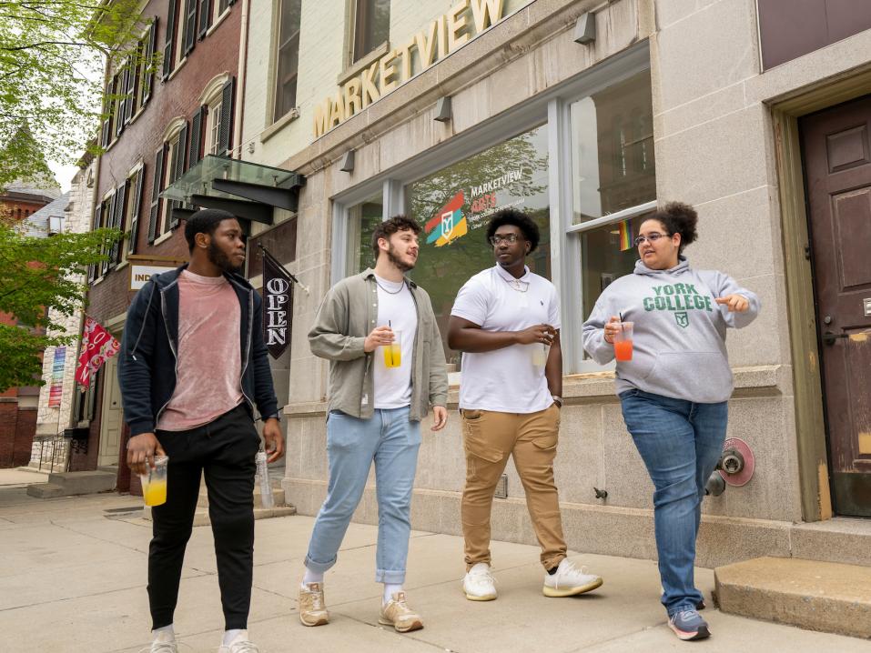 Four students walk past Marketview Arts in Downtown York.