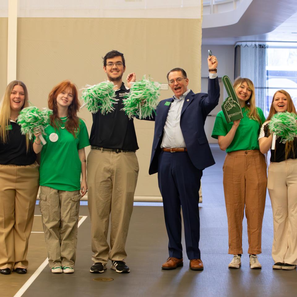 Dr. Burns stands with a group of cheering student during Accepted Student Day