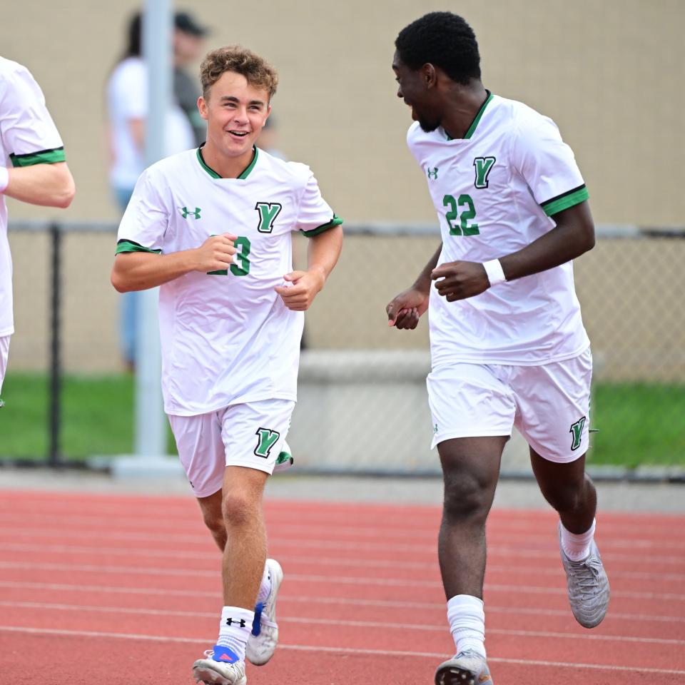 A group of Men's Soccer players run onto the field.