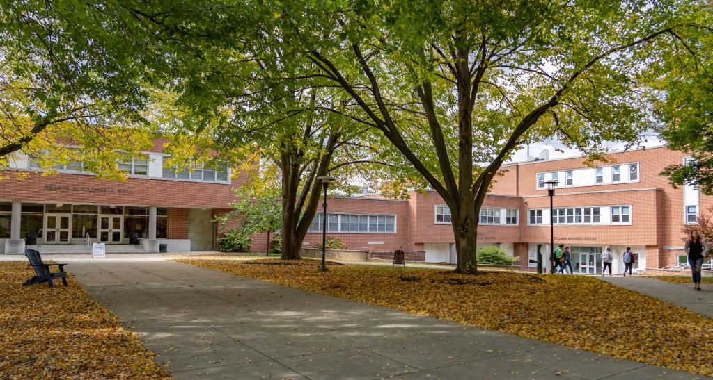 An exterior photo shows the brick front of Campbell Hall and a sidewalk lined with trees.