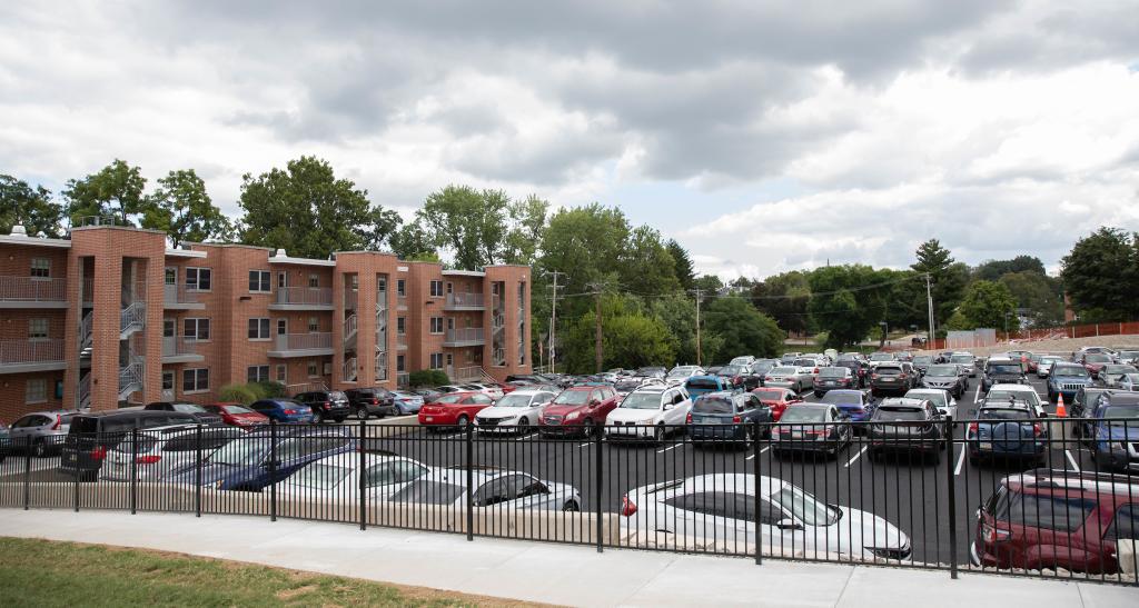 Cars are parked in a campus parking lot. 