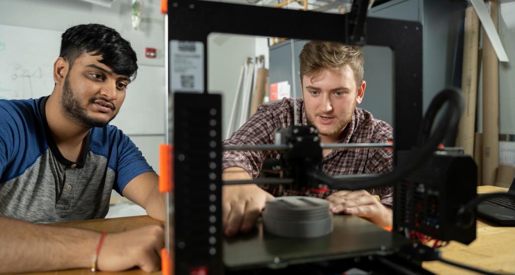 Two students examine equipment in the engineering lab.