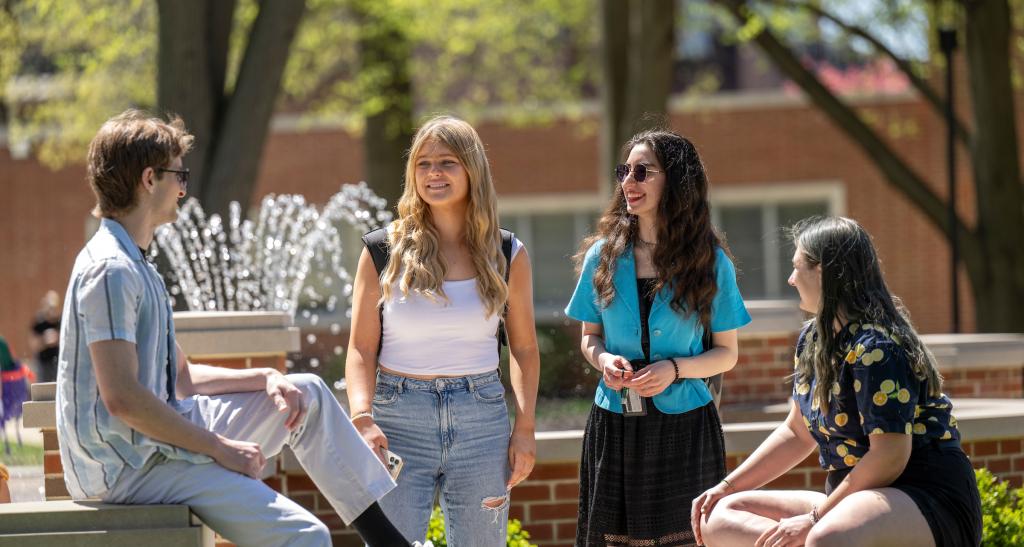 Group of students hanging out near the campus fountain.