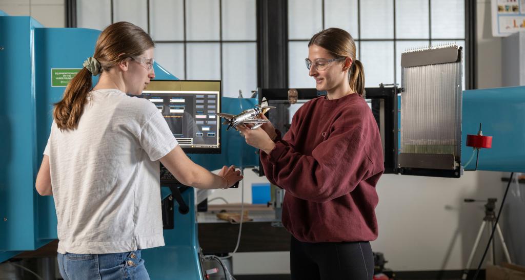 Two students work with equipment in the mechanical engineering lab.