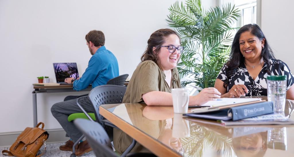 Two York College of Pennsylvania students in a Business Graduate program review a report.