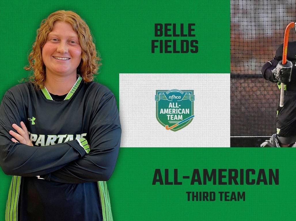 Belle Fields poses in front of a NFHCA All-American Third Team poster.