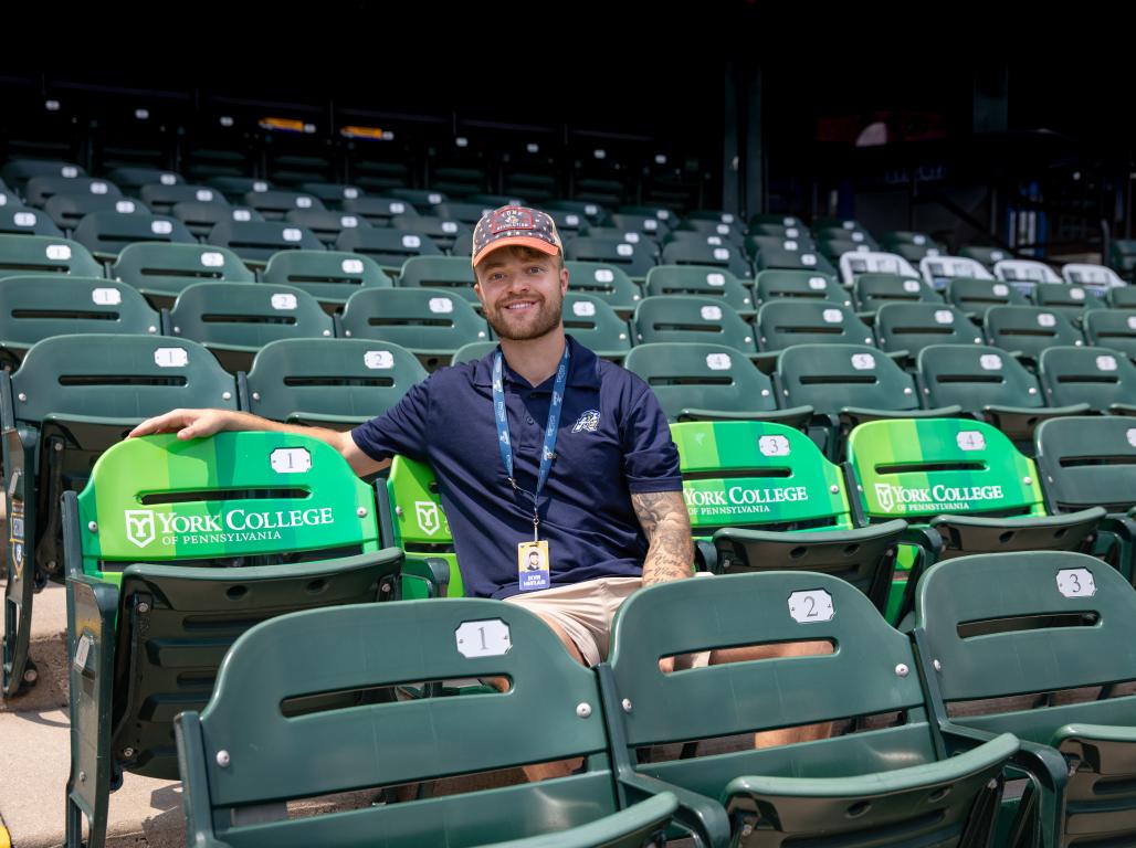 Devin Hartlaub sitting in the YCP-branded seats at WellSpan Park.