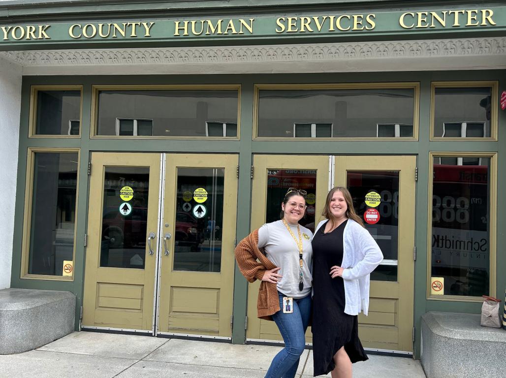 Taylor Anderson and friend standing in front of the York County Human Services Center building.