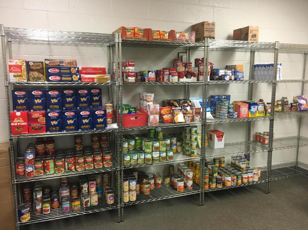 A variety of non-perishable and canned food items are organized on metal shelves