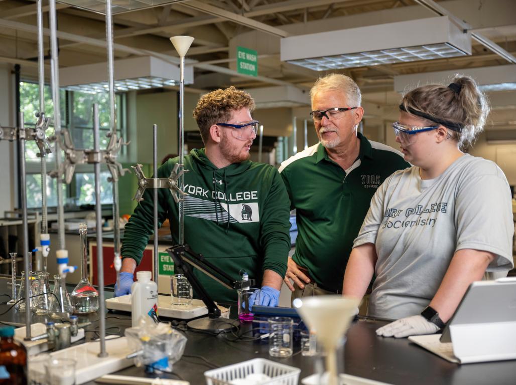 Dr. Greg Foy, professor of chemistry at York College of Pennsylvania, (center) stands with two students in the lab.