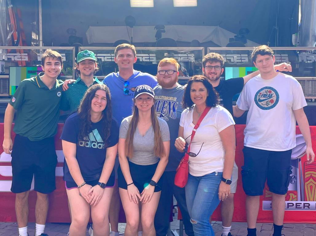 A group of YCP students smiling at the camera in a sport facility.