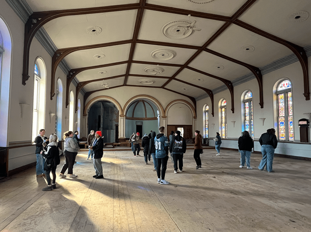 People milling around inside an abandoned historic church.