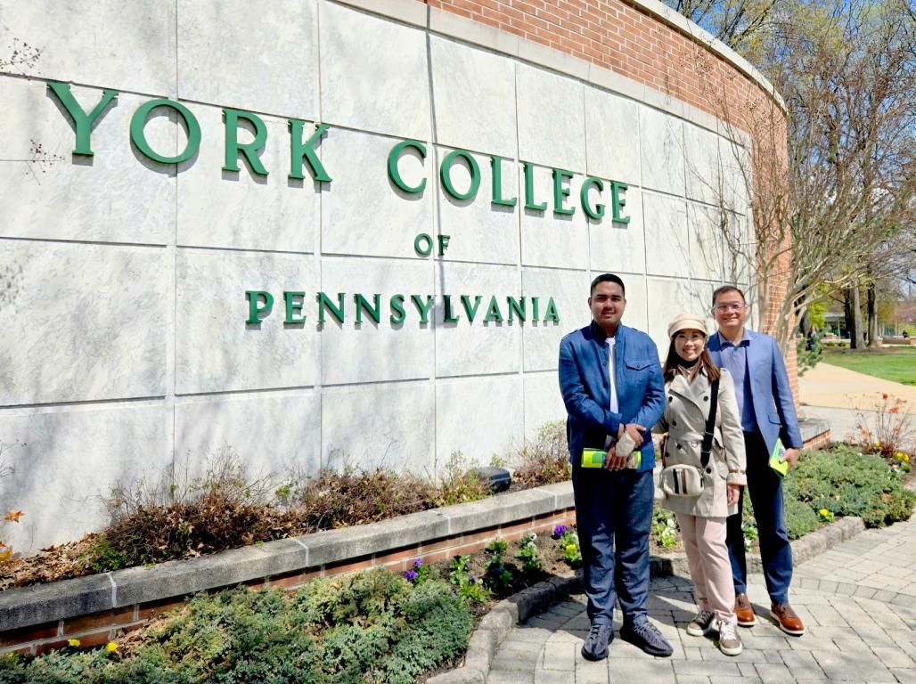 Emanuele “Carlos” Eusebio stands with his parents at the York College sign