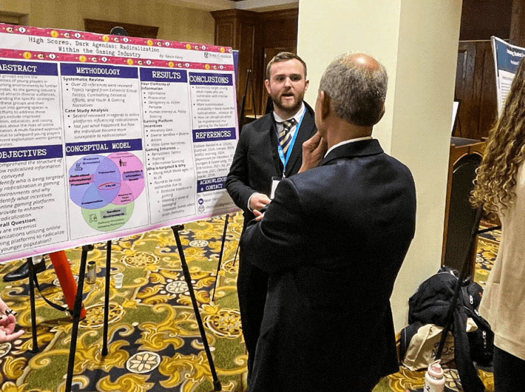 Person presenting a research poster at an academic event.