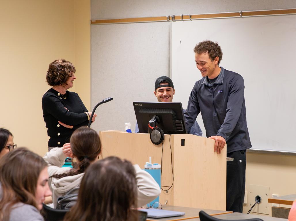A student stands at the podium in a classroom addressing the class