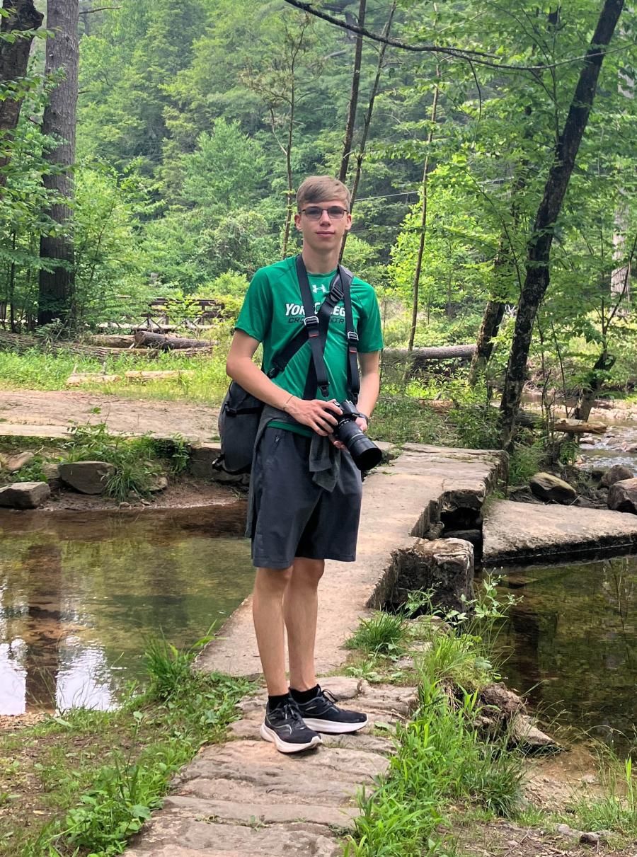 Civil Engineering student Aidan Kissner standing near a stream