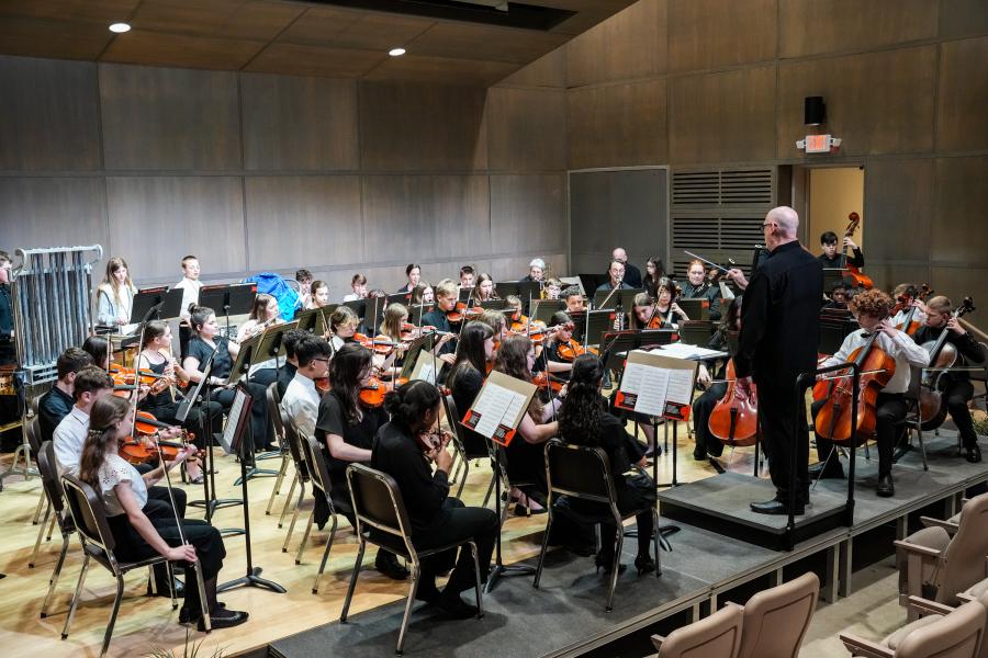 A large group of young musicians playing instraments in a theater