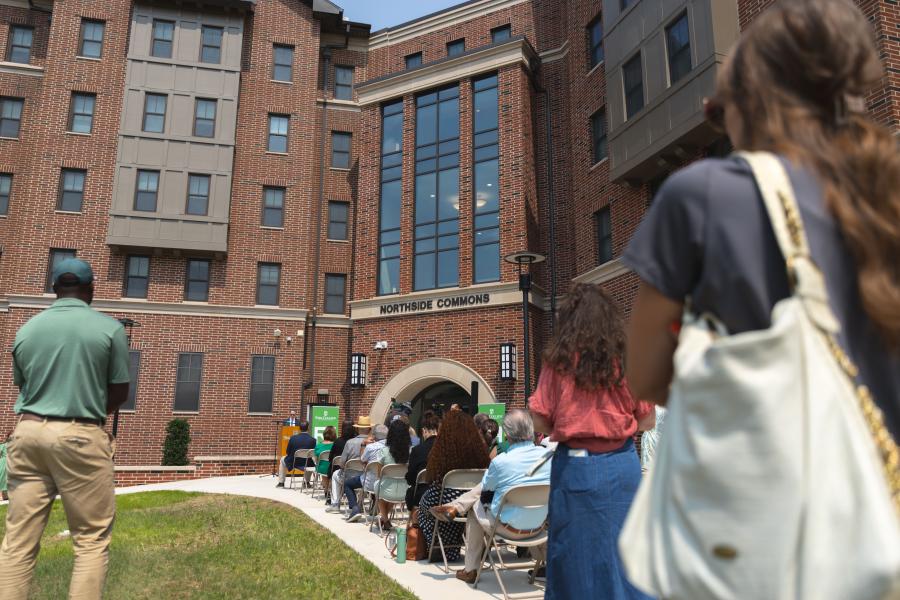 Audience seated outside Northside Commons for a ribbon-cutting ceremony at York College.