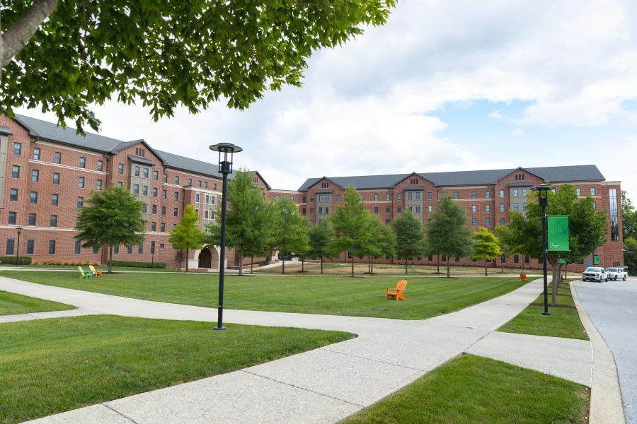 Large green area with grass and trees outside of the large brick buildings of Northside Commons