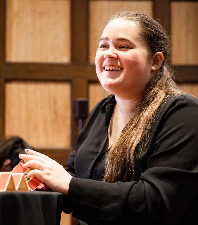 A student prepares table place cards for a gathering. 