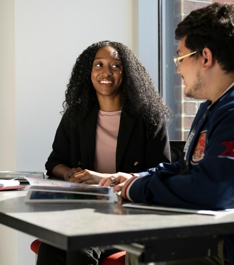 Two students are having a conversation during class