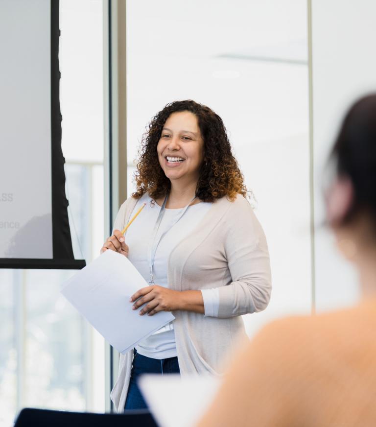 A graduate teacher presenting to a group of students.