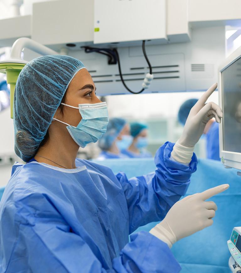 A nurse anesthetist check the montior during surgery.