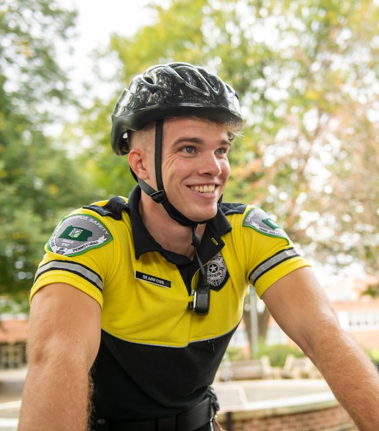 Campus Safety student worker on a bike on campus.