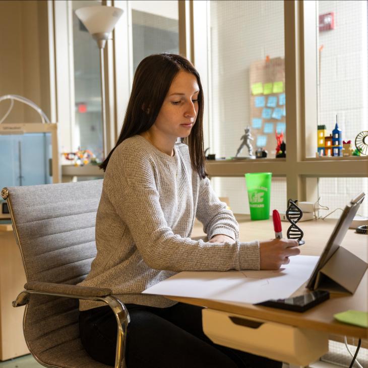 A student in the graham innovation zone studying on a laptop.