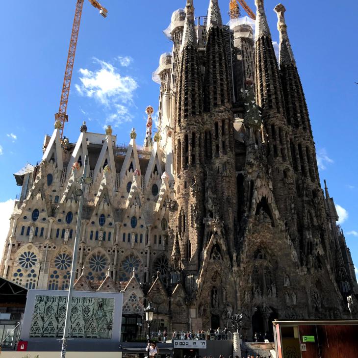 A crowd stands before the La Sagrada Familia church in Spain.