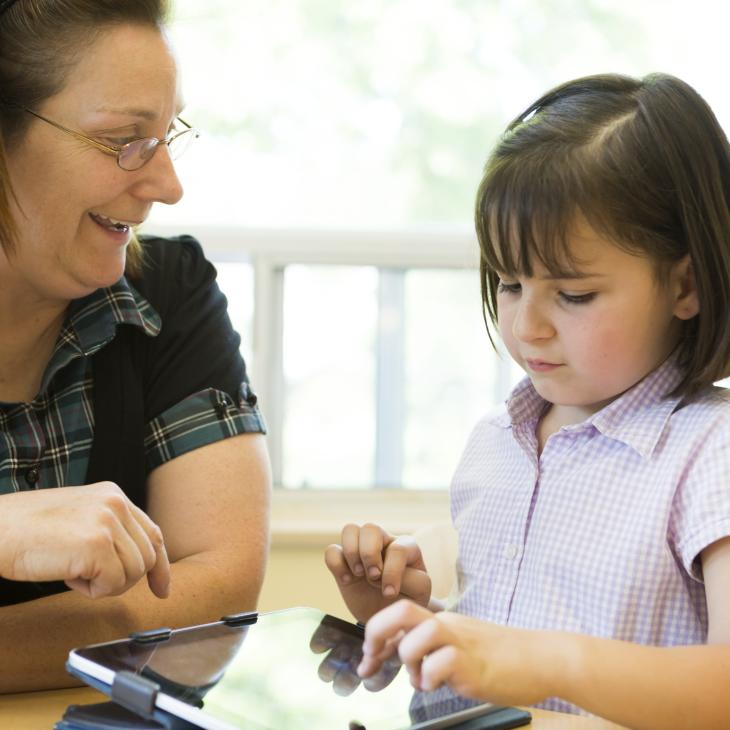 A teacher helping a young student.