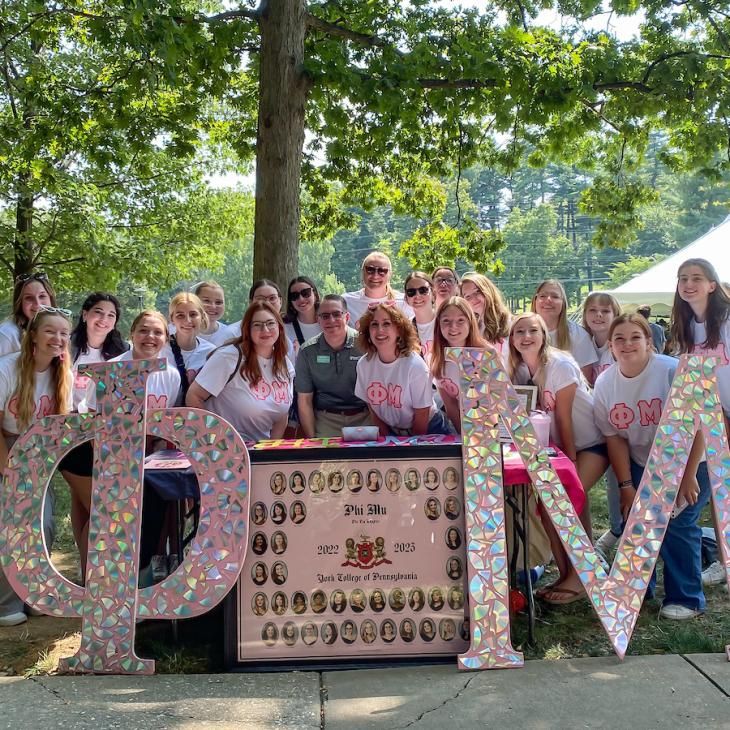 Phi Mu posing with Dr. Burns at the Involvement Fair.