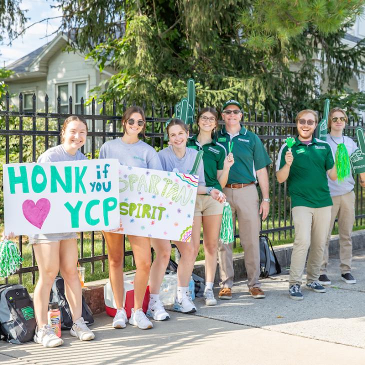 A group of students and the president cheering during Move In Day.