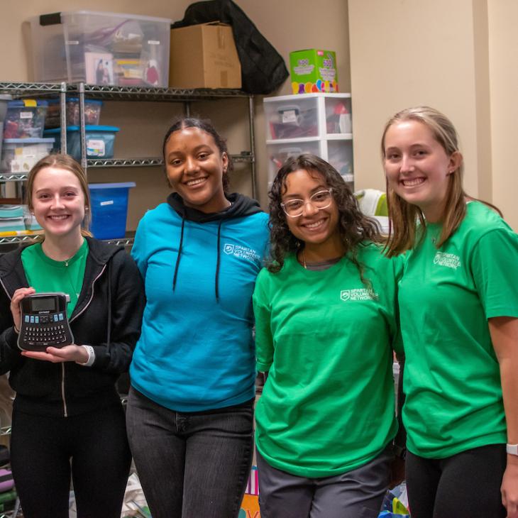 A group of students volunteering, smiling.