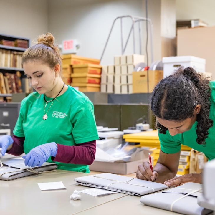 Two students in the Spartan Volunteer Network working together.