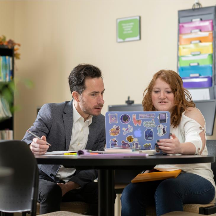 Professor helping a student on their laptop