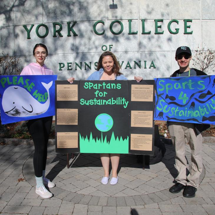 students holding signs to promote sustainability