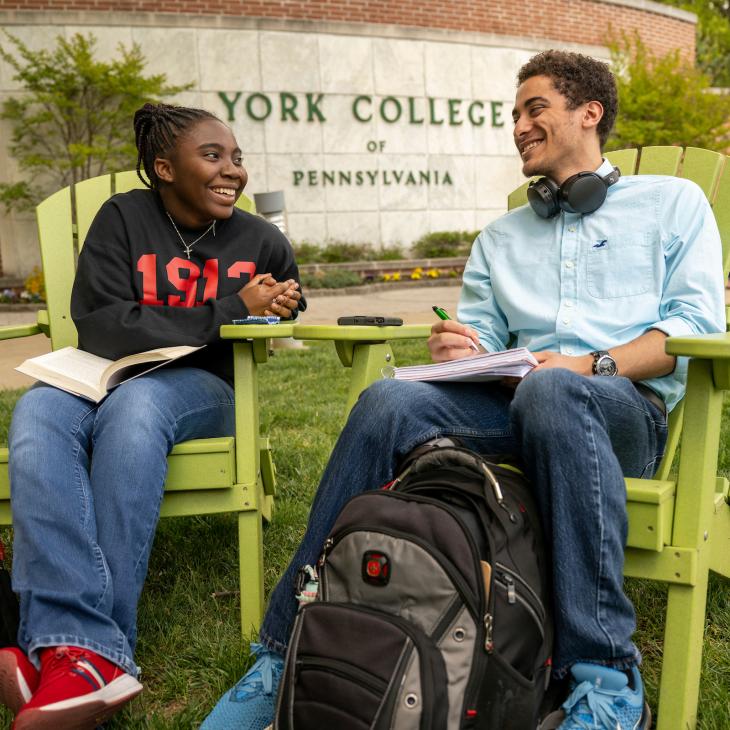 Students sitting in adirondack chairs