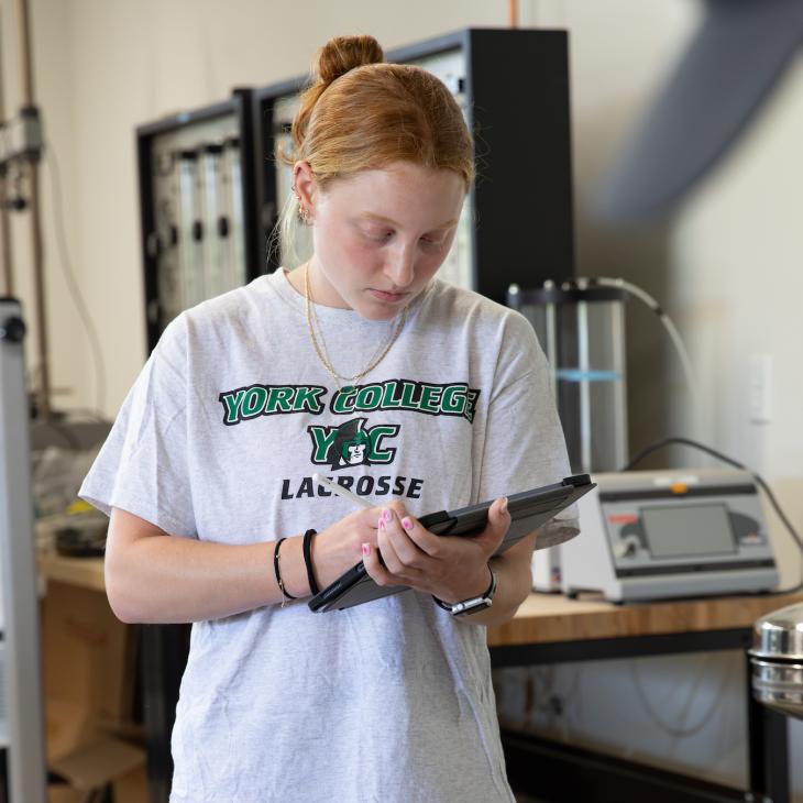 student looking at ipad in engineering lab