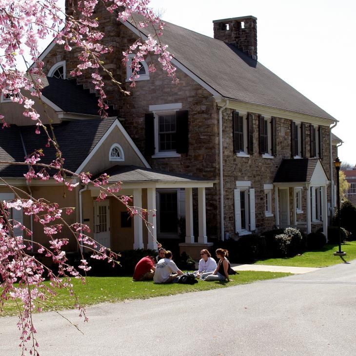 A group of student sitting in front of Broucher Chapel in the spring.