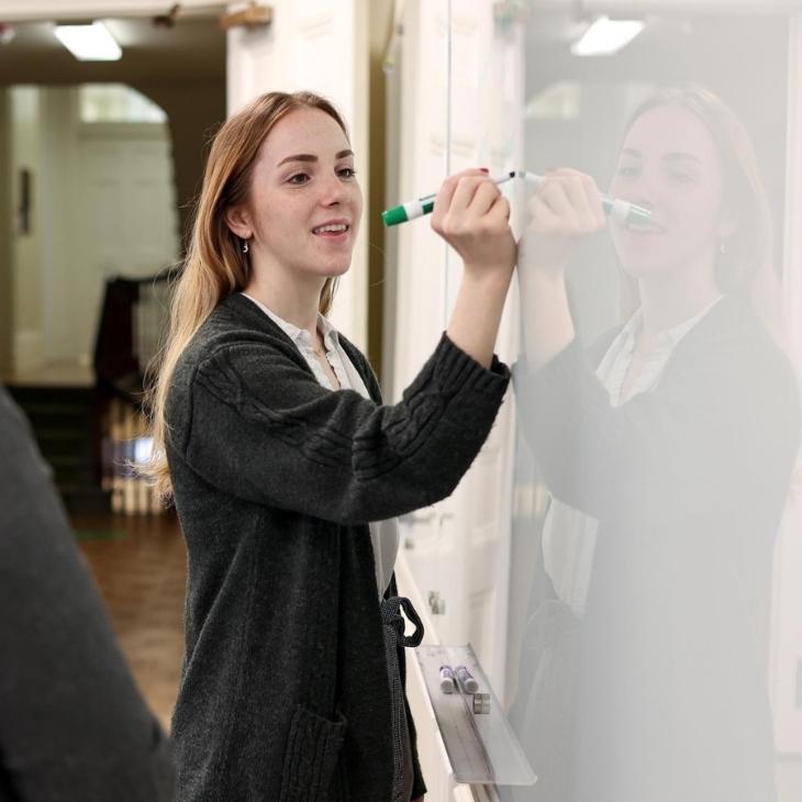 York College MPPA student writes on white board.