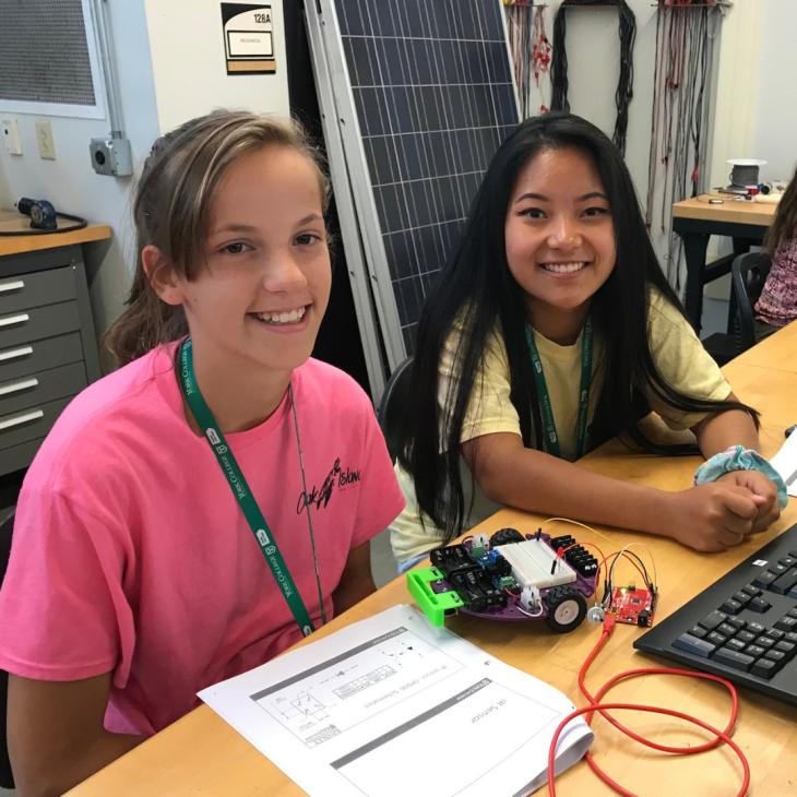 Two girls smile during a robotics class at York College of Pennsylvania.