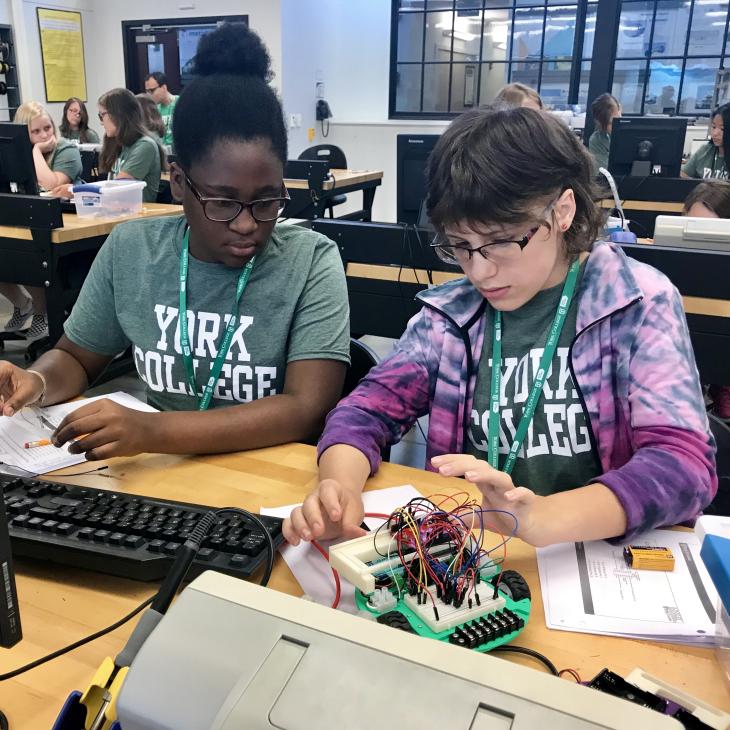 Two girls working on a robot