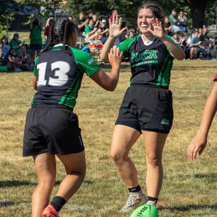 Women's Rugby players high five during a game